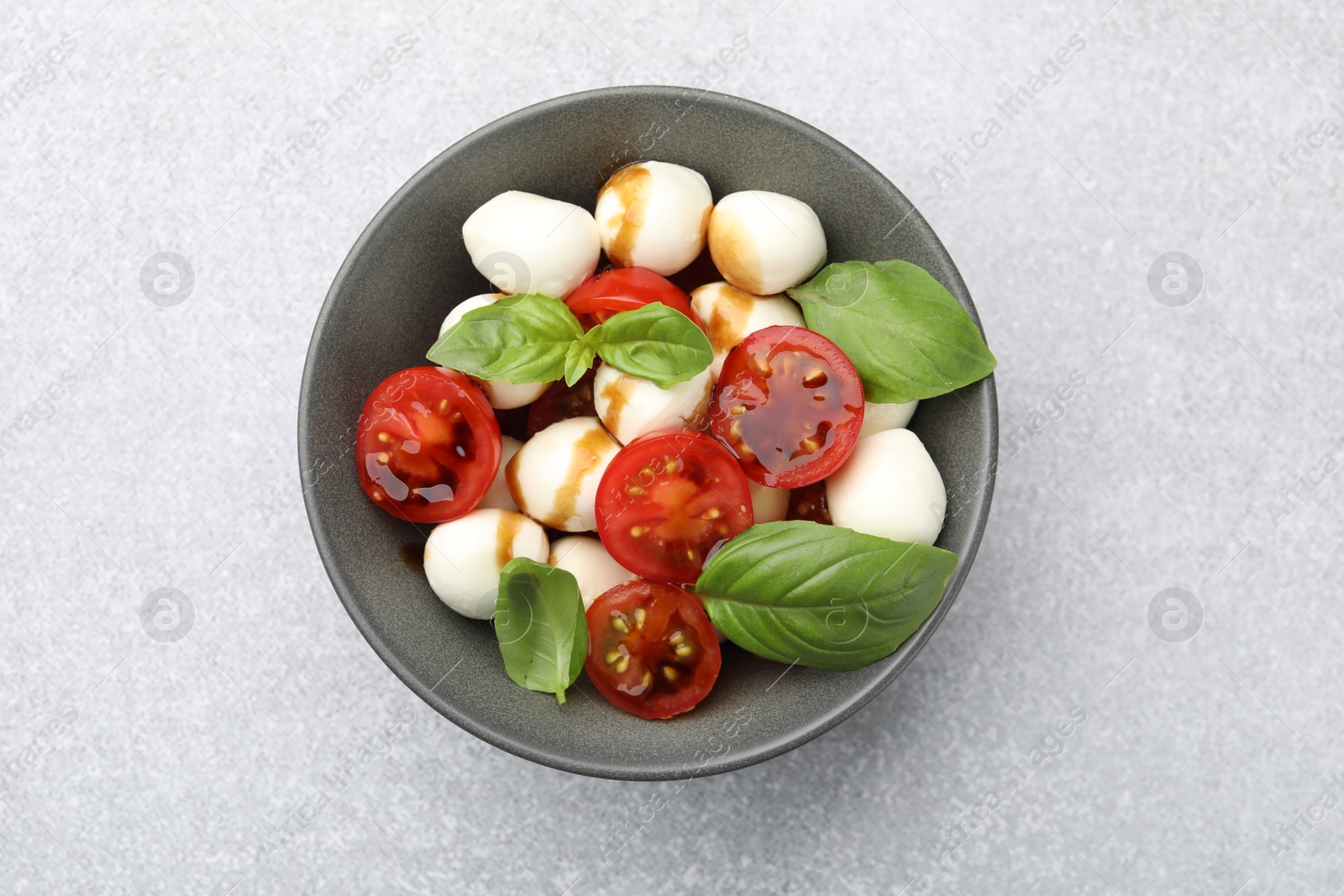 Tasty salad with mozzarella, tomatoes and basil on light table, top view Photo of Tasty salad with mozzarella, tomatoes and basil on light table, top view