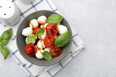 Photo of Tasty salad with mozzarella, tomatoes and basil on light table, flat lay. Space for text