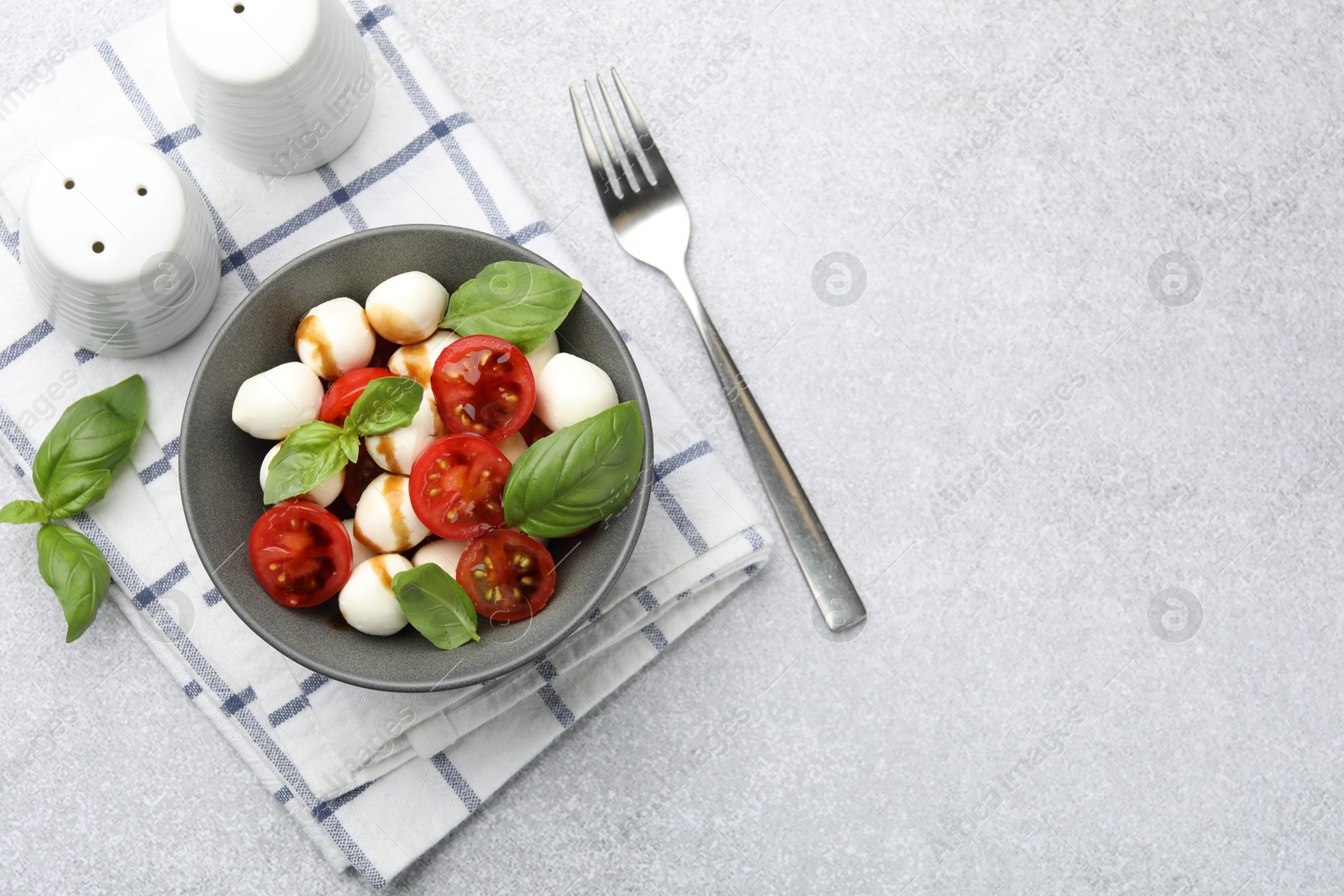 Tasty salad with mozzarella, tomatoes and basil served on light table, flat lay. Space for text Photo of Tasty salad with mozzarella, tomatoes and basil served on light table, flat lay. Space for text