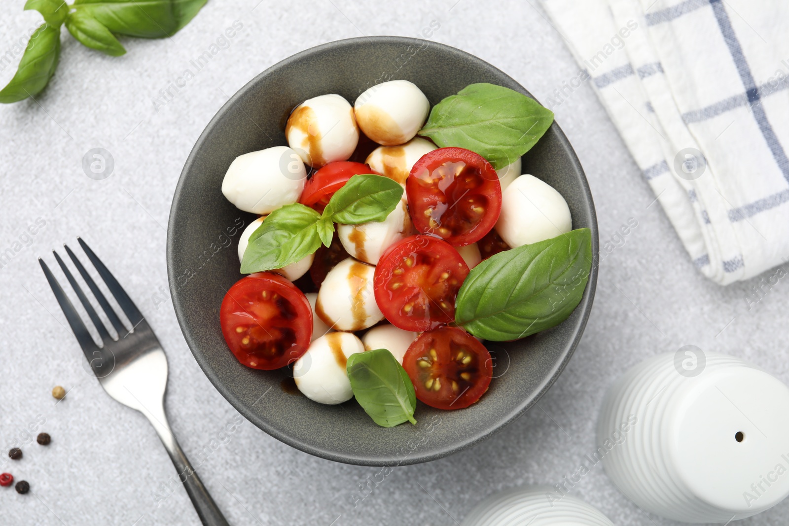 Tasty salad with mozzarella, tomatoes and basil served on light table, flat lay Photo of Tasty salad with mozzarella, tomatoes and basil served on light table, flat lay