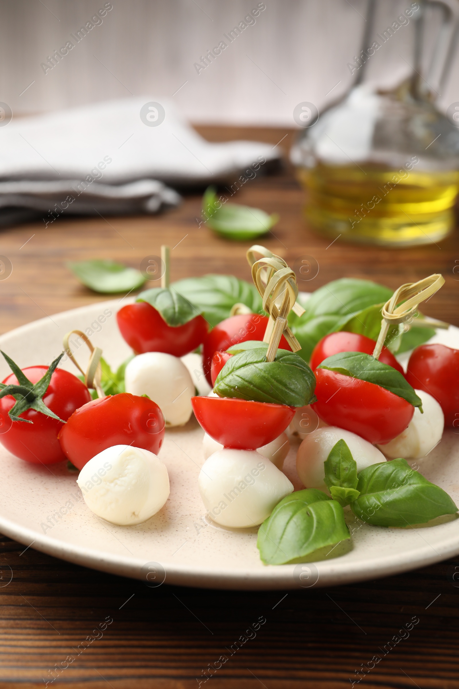 Appetizers with mozzarella, tomatoes and basil on wooden table, closeup Photo of Appetizers with mozzarella, tomatoes and basil on wooden table, closeup