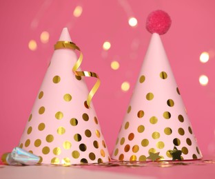 Photo of Party hats and festive decor on pink background