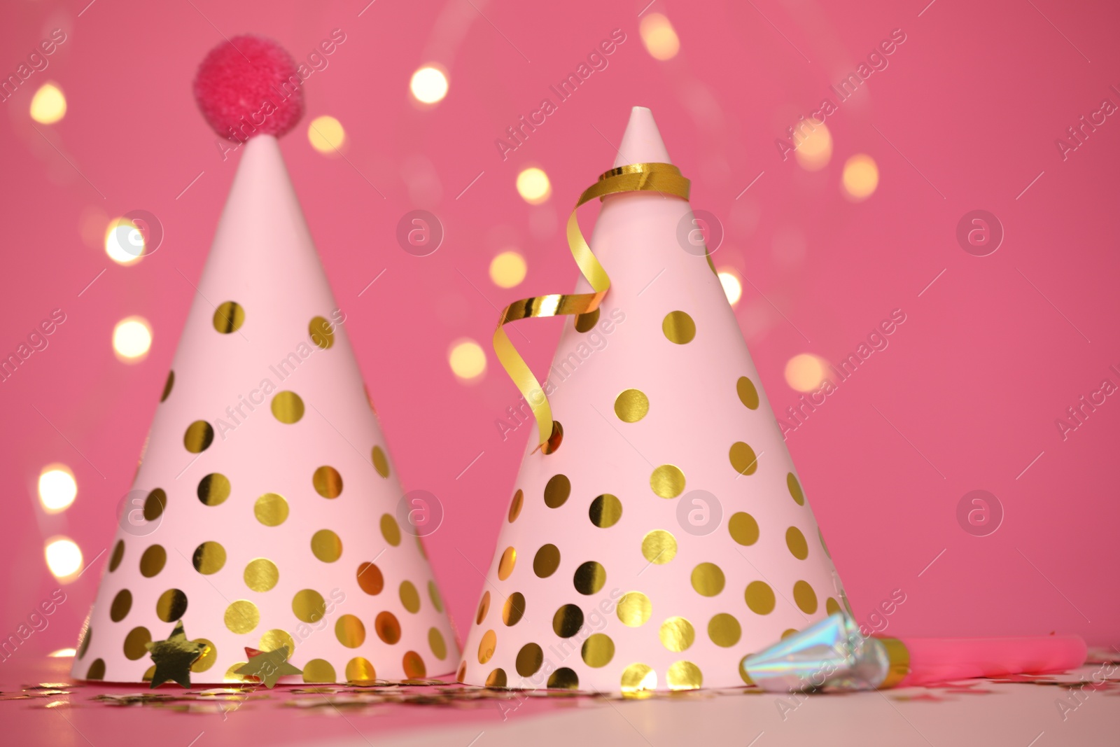 Party hats and festive decor on pink background Photo of Party hats and festive decor on pink background