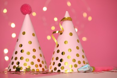 Photo of Party hats and festive decor on pink background