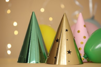 Photo of Party hats and festive decor on color background