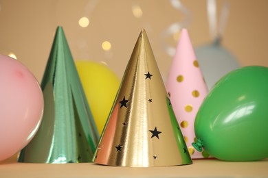 Photo of Party hats and festive decor on color background