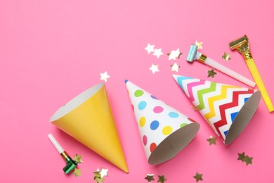 Photo of Party hats and festive decor on pink background, flat lay. Space for text