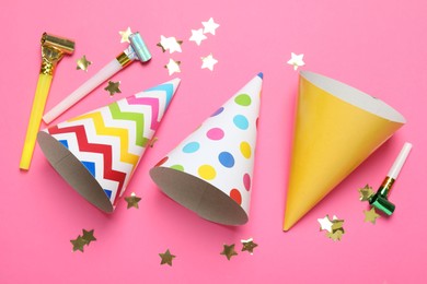 Photo of Party hats and festive decor on pink background, flat lay