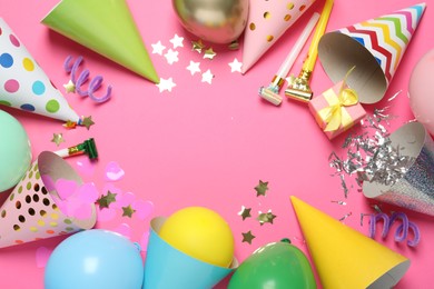Photo of Frame of party hats and festive decor on pink background, flat lay. Space for text