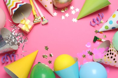 Photo of Frame of party hats and festive decor on pink background, flat lay. Space for text