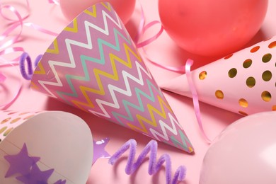 Photo of Party hats and festive decor on pink background, flat lay
