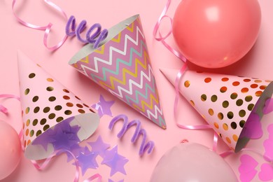 Photo of Party hats and festive decor on pink background, flat lay