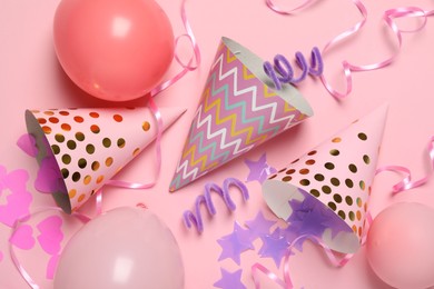Photo of Party hats and festive decor on pink background, flat lay