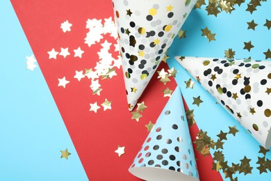 Photo of Party hats and festive decor on color background, flat lay