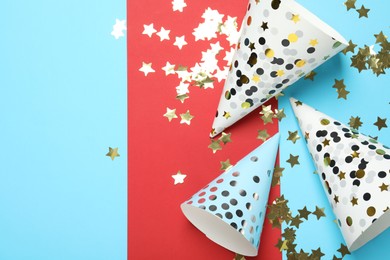 Photo of Party hats and festive decor on color background, flat lay. Space for text