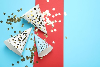 Photo of Party hats and festive decor on color background, flat lay. Space for text