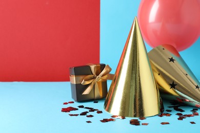 Photo of Party hats and festive decor on color background. Space for text