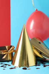 Photo of Party hats and festive decor on color background
