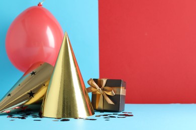 Photo of Party hats and festive decor on color background. Space for text