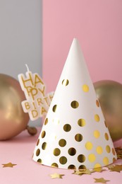 Photo of Party hat and festive decor on color background