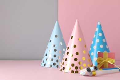 Photo of Party hats and festive decor on color background. Space for text