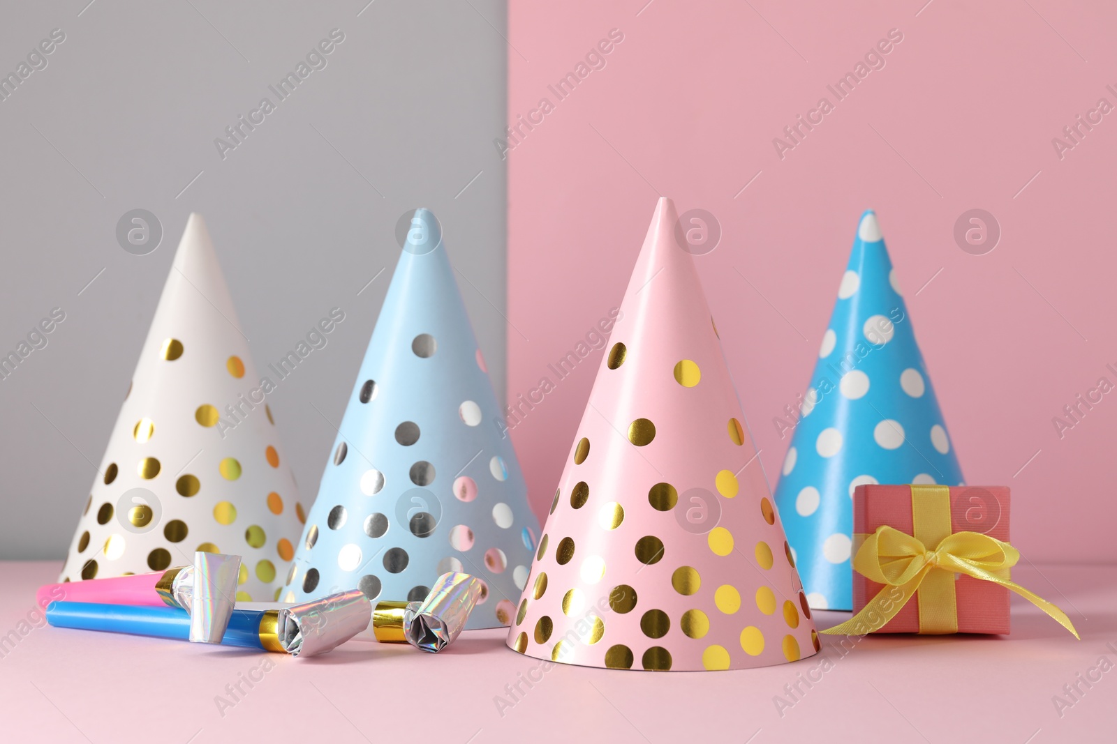 Party hats and festive decor on color background Photo of Party hats and festive decor on color background