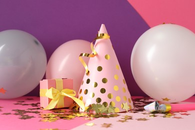 Photo of Party hat and festive decor on color background
