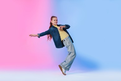 Photo of Girl in stylish clothes dancing on color background