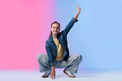 Photo of Girl in stylish clothes dancing on color background