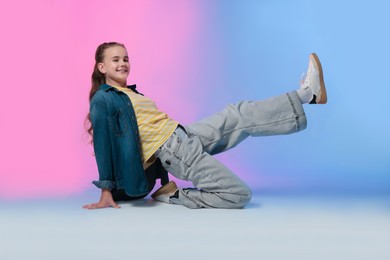 Photo of Girl in stylish clothes dancing on color background