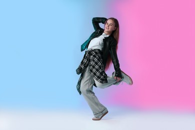 Photo of Girl in stylish clothes dancing on color background