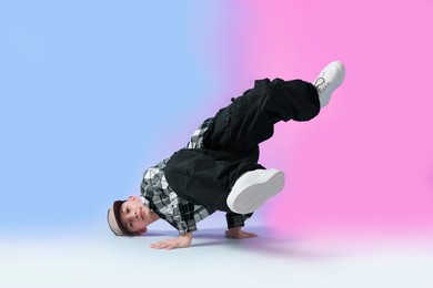 Photo of Boy in stylish clothes dancing on color background