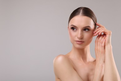 Photo of Portrait of beautiful young woman on gray background, space for text