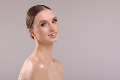 Photo of Portrait of beautiful young woman on gray background, space for text