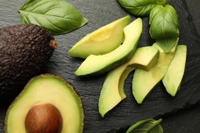 Photo of Tasty ripe green avocados and basil on table, flat lay