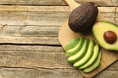 Photo of Tasty ripe green avocados on wooden table, top view. Space for text