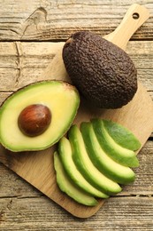 Photo of Tasty ripe green avocados on wooden table, top view