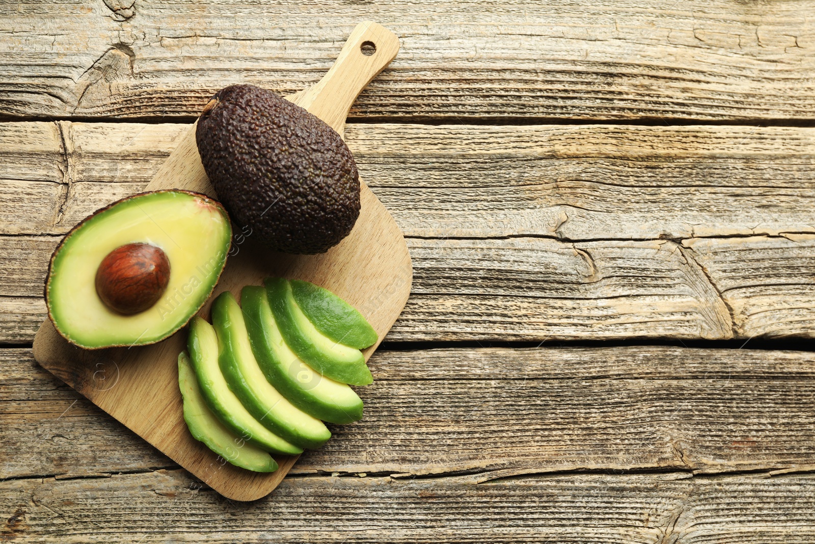 Tasty ripe green avocados on wooden table, top view. Space for text Photo of Tasty ripe green avocados on wooden table, top view. Space for text