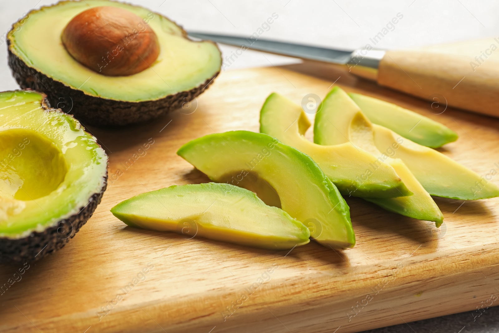 Cut ripe green avocados and knife on table, closeup Photo of Cut ripe green avocados and knife on table, closeup
