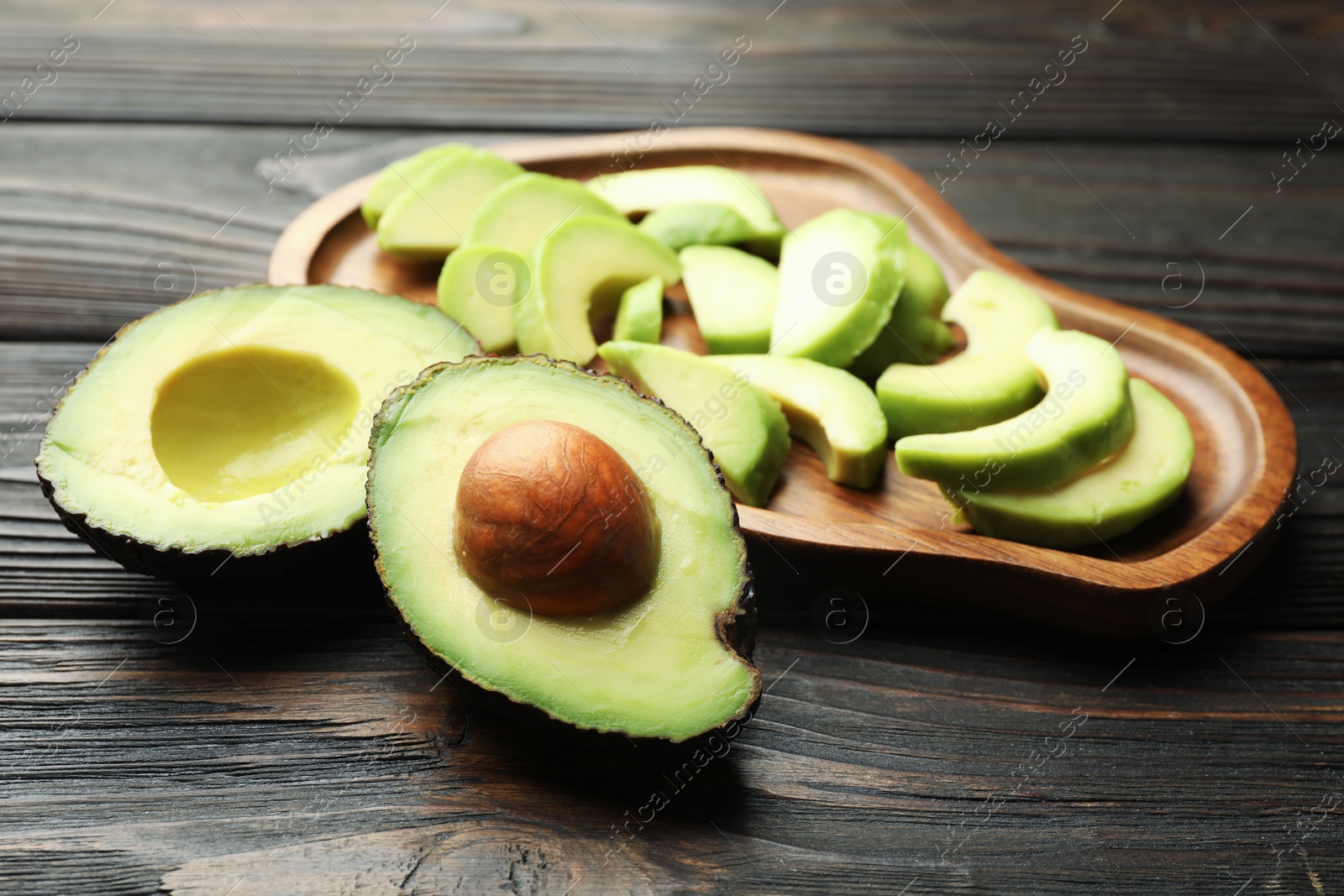 Cut ripe green avocados on wooden table, closeup Photo of Cut ripe green avocados on wooden table, closeup