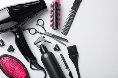 Photo of Different hairdresser's tools on light grey background, flat lay. Space for text