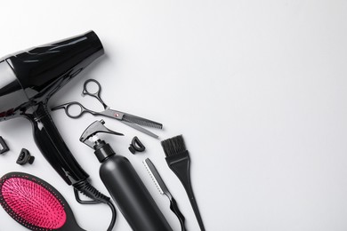 Photo of Different hairdresser's tools on light grey background, flat lay. Space for text