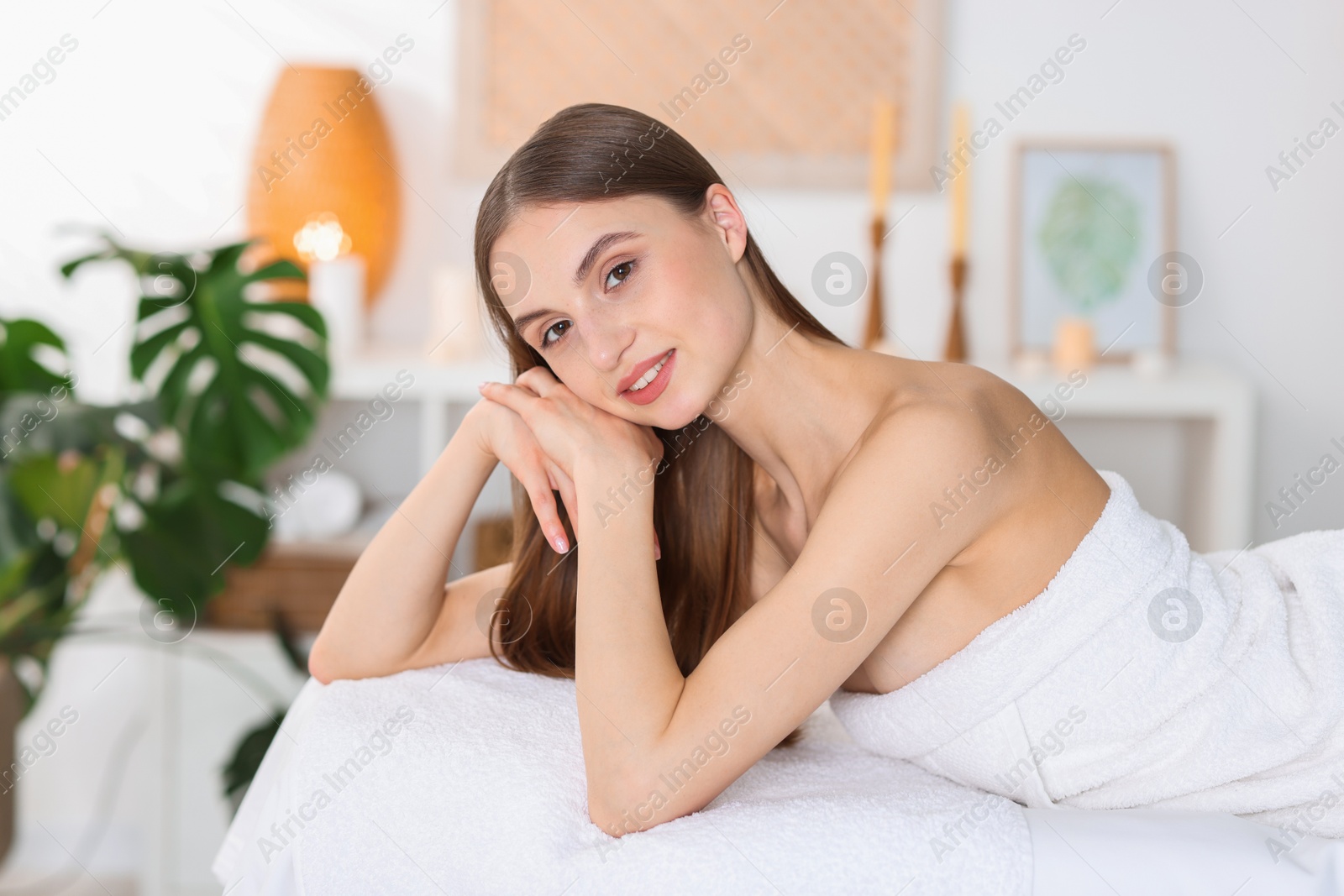Portrait of smiling woman on massage couch in spa salon Photo of Portrait of smiling woman on massage couch in spa salon