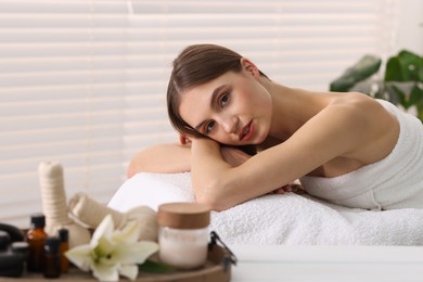 Photo of Beautiful woman relaxing on massage couch in spa salon, selective focus