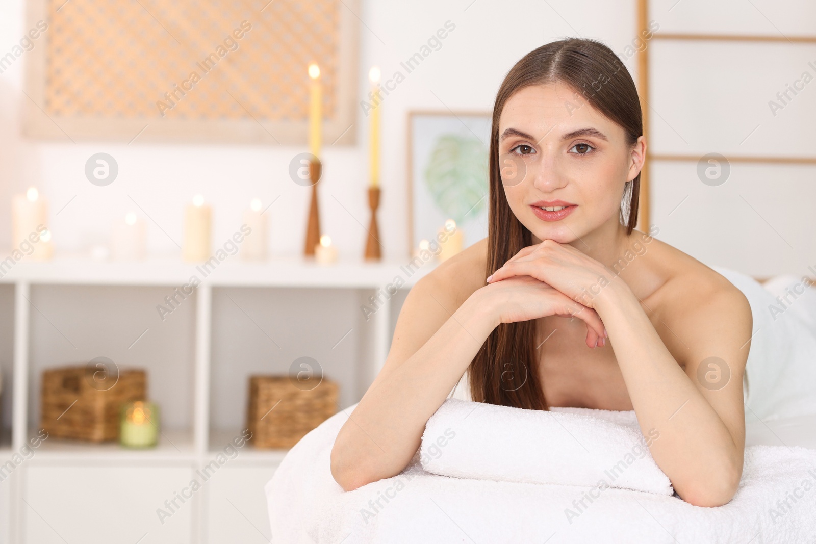 Portrait of beautiful woman on massage couch in spa salon. Space for text Photo of Portrait of beautiful woman on massage couch in spa salon. Space for text