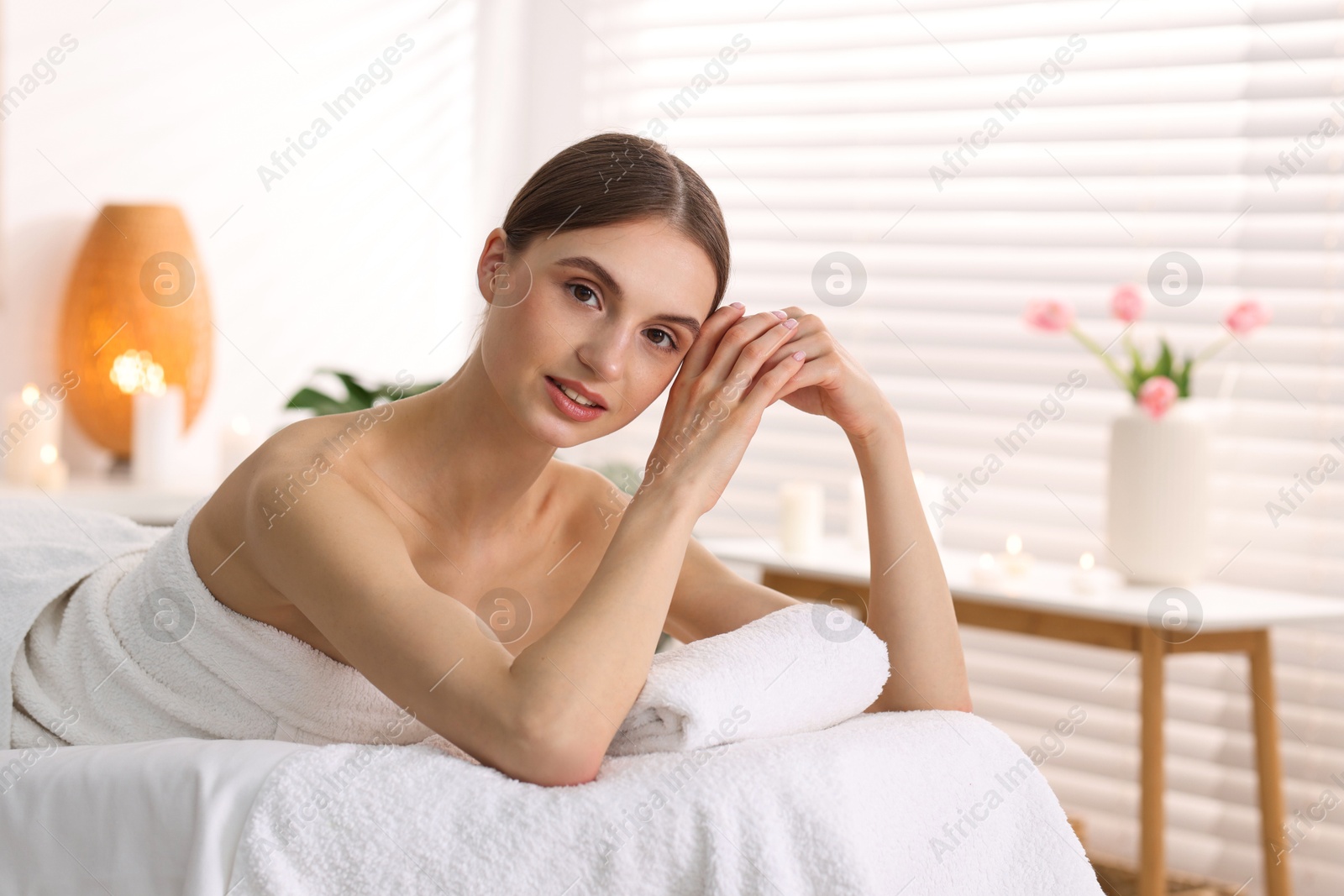 Portrait of beautiful woman on massage couch in spa salon Photo of Portrait of beautiful woman on massage couch in spa salon
