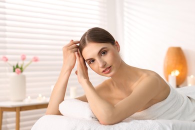Photo of Portrait of beautiful woman on massage couch in spa salon