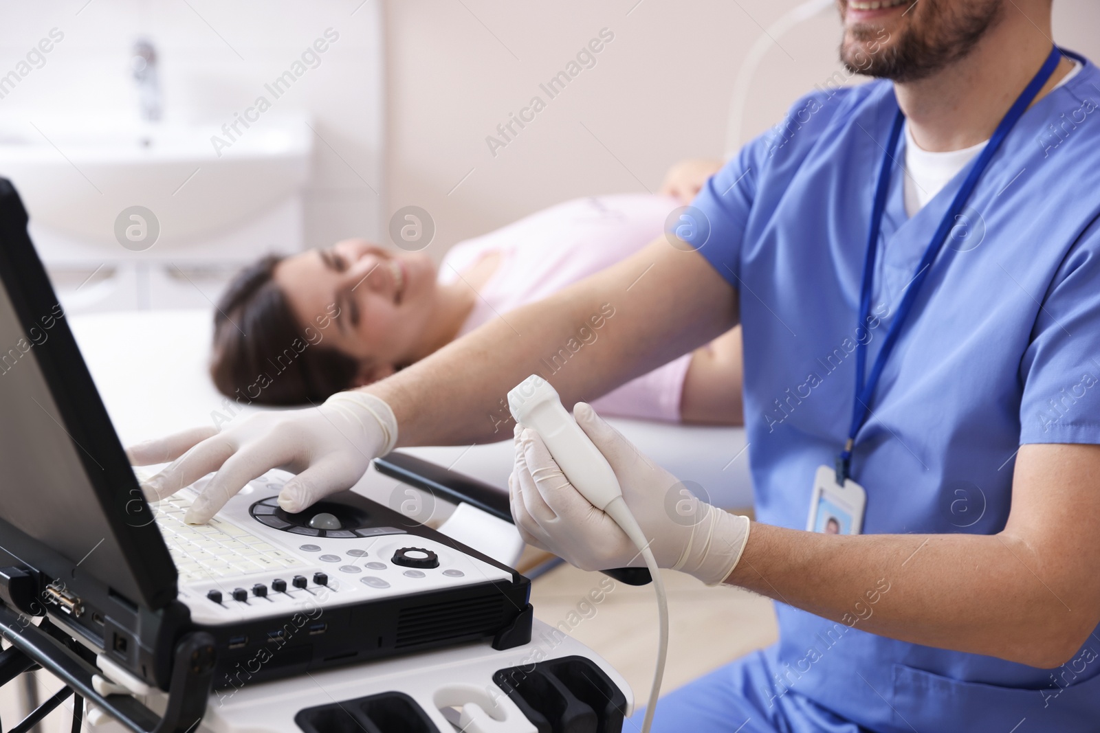 Sonographer with ultrasound transducer and woman waiting for examination in clinic, selective focus Photo of Sonographer with ultrasound transducer and woman waiting for examination in clinic, selective focus