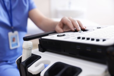Photo of Professional sonographer with ultrasound machine in clinic, closeup