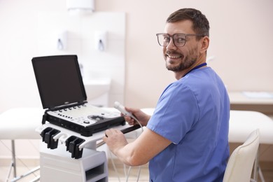 Photo of Professional sonographer with ultrasound machine in clinic